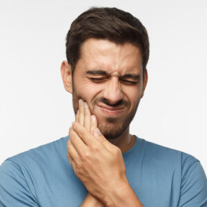 A man experiencing a toothache in need of emergency dental services in Parker, Colorado.