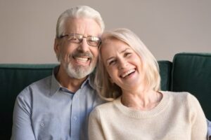 A Colorado man and woman sit together and smile showing the benefits of dental bonding services from Twin Aspen Dental Center.