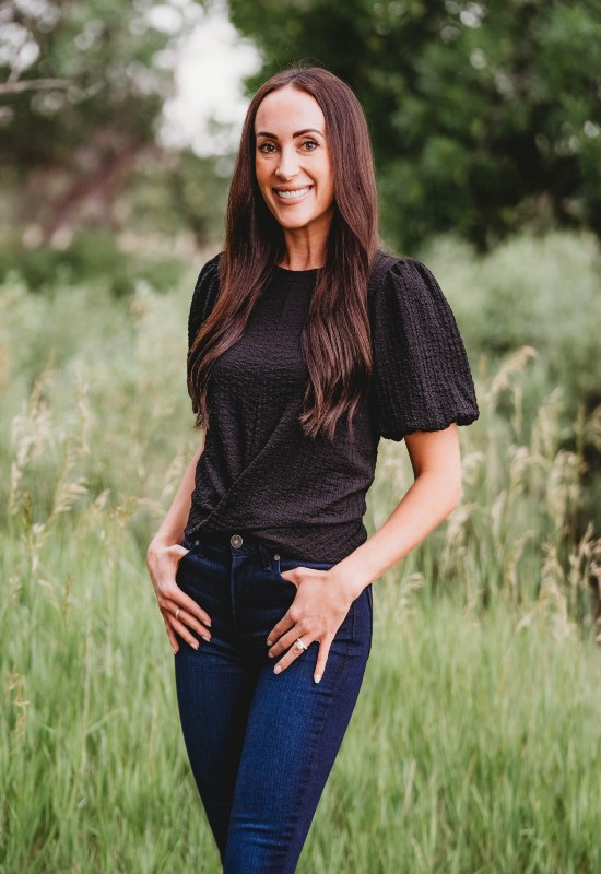 Dr. Alyssa Snyder-Mughal, who works at Twin Aspen Dental Center, is posing happily in Parker, CO