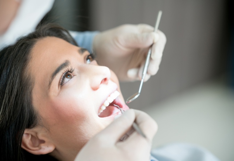 A woman is getting her dental check-up by a dentist in Parker, CO