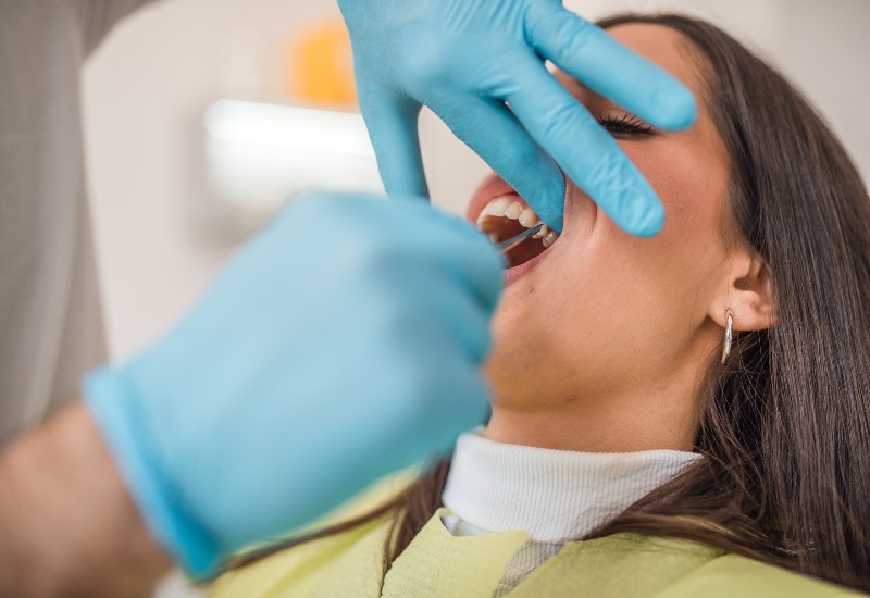 A dental professional is performing tooth extractions on a patient in Parker, CO
